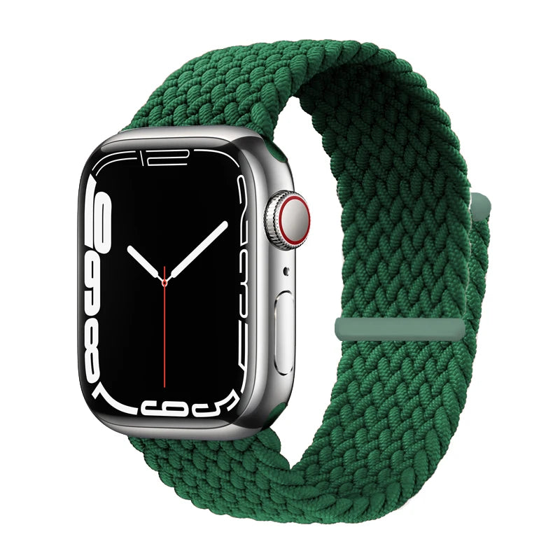 A silver Apple Watch is shown with a dark green braided stretch band around it.