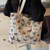 A beige bohemian corduroy tote bag featuring a pattern of colorful butterflies and foliage.