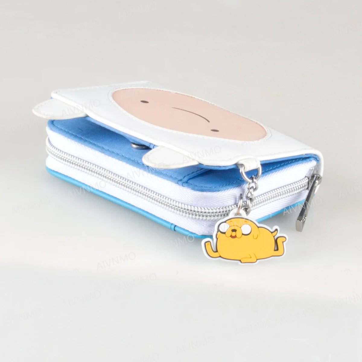 A white and blue anime trifold zipper wallet with a yellow cat charm attached to the zipper pull.