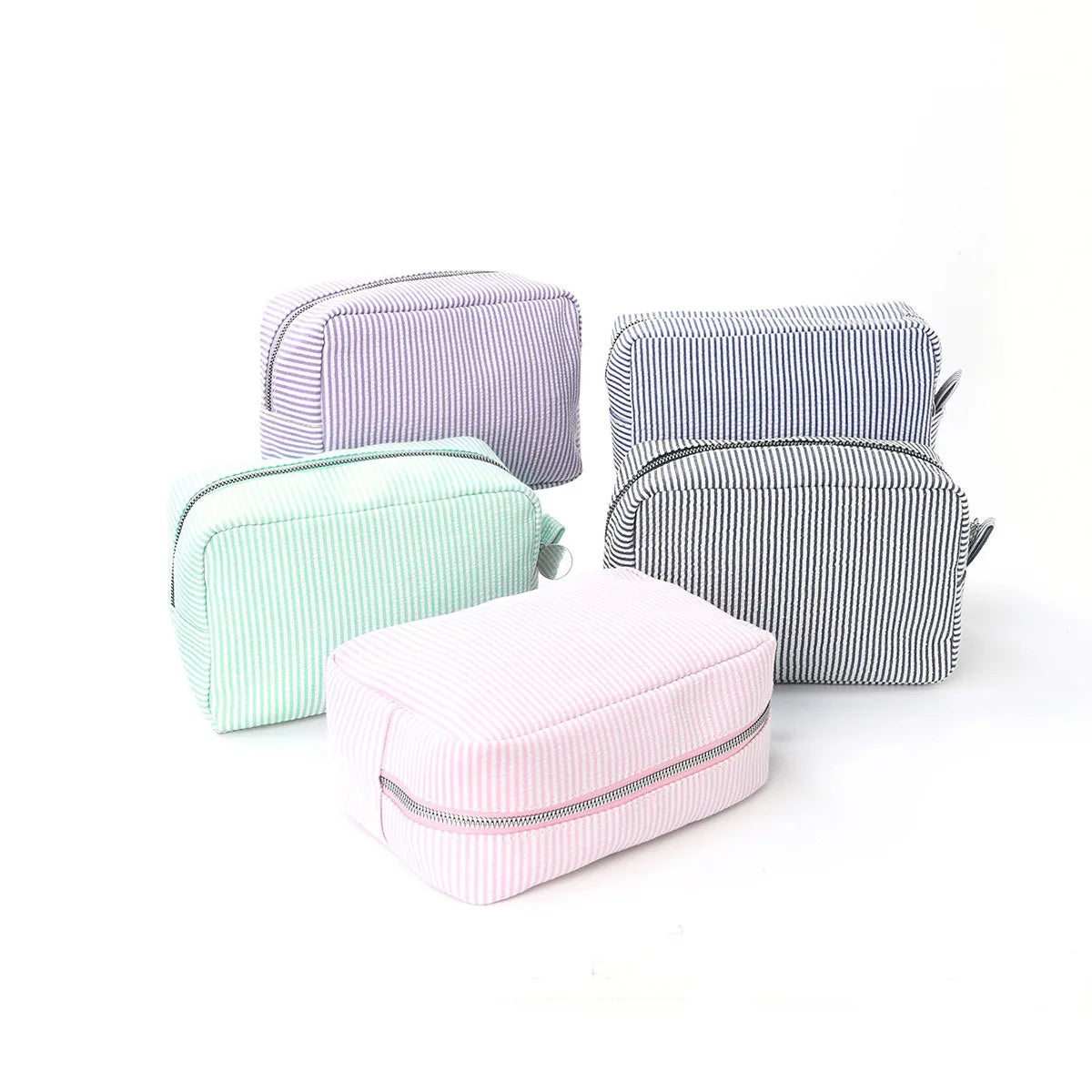 Three cosmetic bags in pastel stripes—lavender, mint green, and pink—with zipper closures.