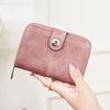 A close-up of a pink vintage RFID blocking multi-function women's wallet being held by hands.