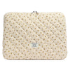 Funda acolchada para portátil de color crema con estampado floral amarillo.