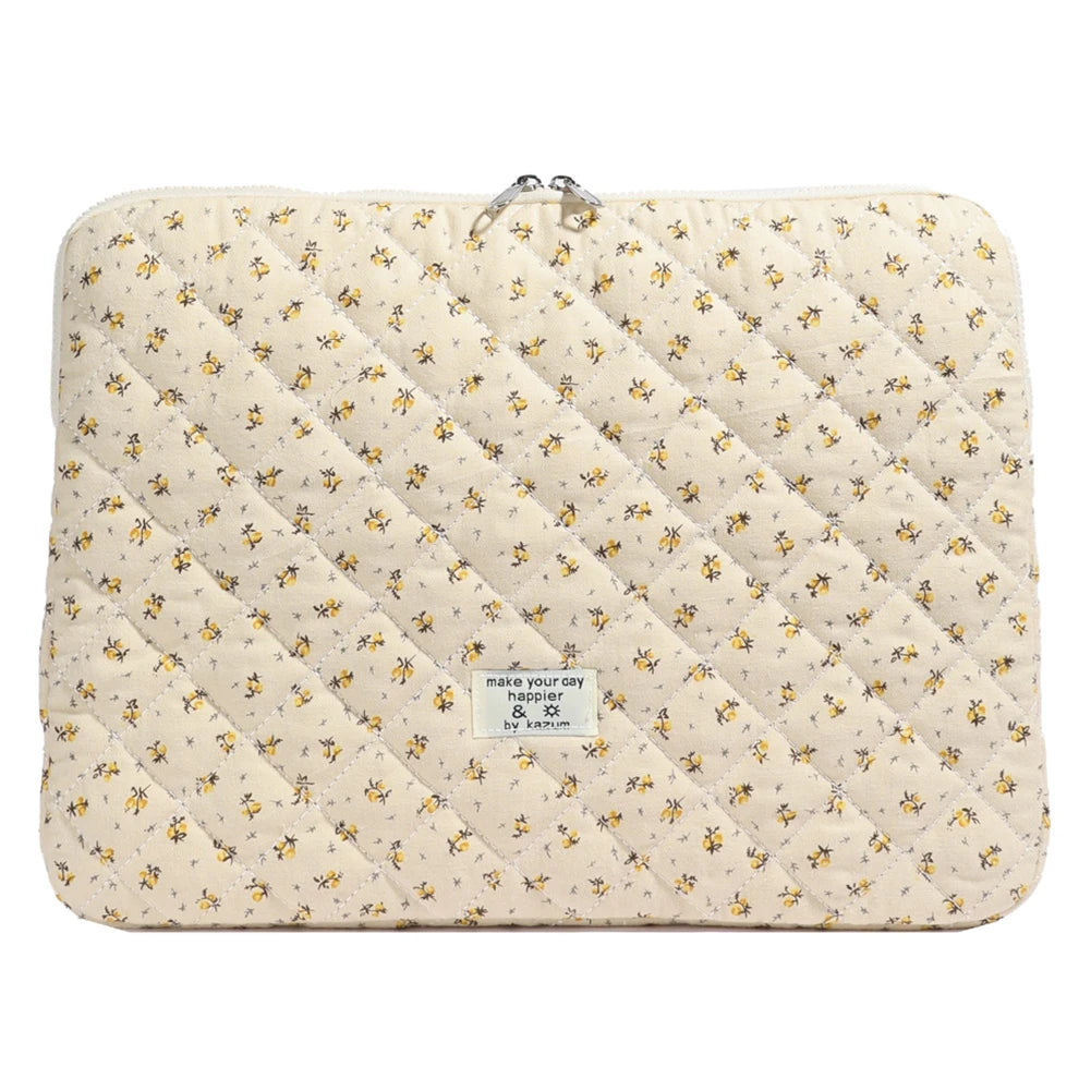 Funda acolchada para portátil de color crema con estampado floral amarillo.