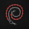 A silver chain necklace featuring red and white dice beads forming a circular pattern.
