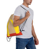 A man is holding a beige and yellow kraft paper drawstring bag with black cord.