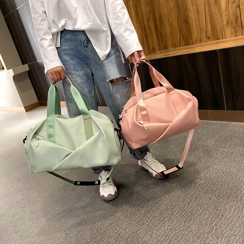 A person holds a pink duffel bag with light green straps in a modern indoor setting.