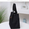 A black durable aluminum foil insulated lunch bag standing on a white surface.