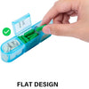 A hand is opening a blue weekly pill organizer with green capsules, showing the flat design for easy filling and taking out.