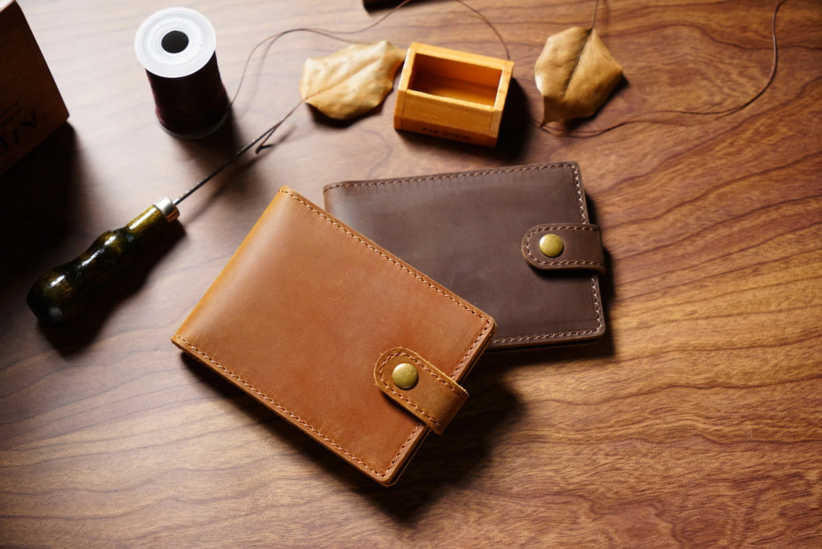 Portefeuille pliable en cuir véritable pour carte d'identité et cartes, posé sur une surface en bois avec des objets connexes