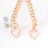 Gold heart-shaped metal purse chain extender displayed on a clear background.