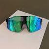 Un par de gafas de sol para ciclismo espejadas en verde y azul, descansando sobre una superficie blanca.