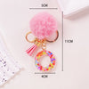 Pink fluffy pom-pom keychain with a shiny resin pendant and alphabet charm