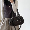 A woman holds a leopard print riveted shoulder bag against a white background.