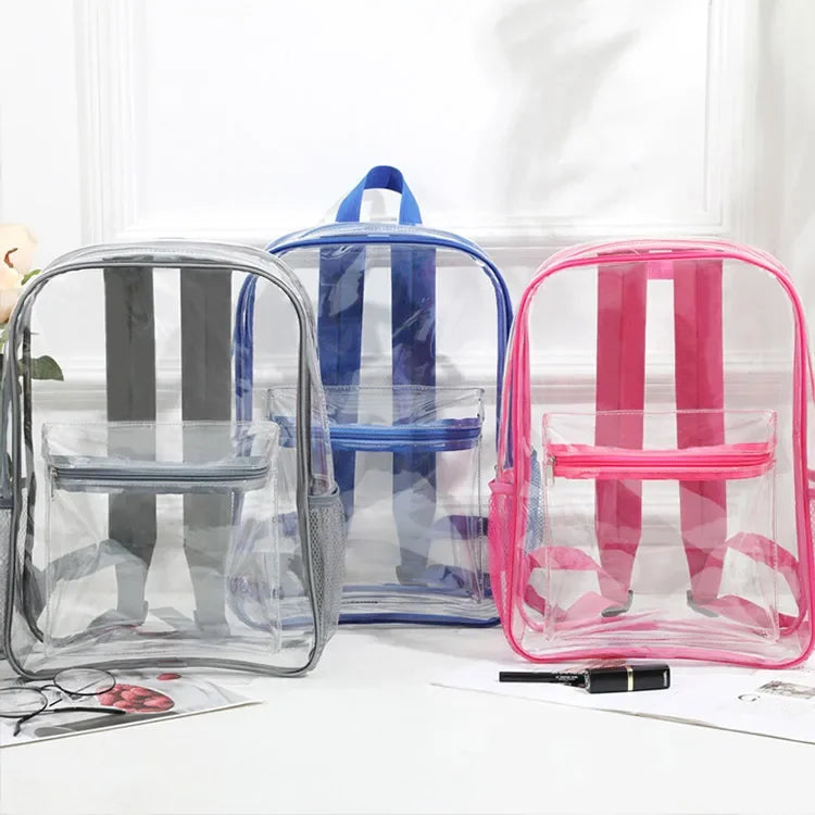 A collection of clear transparent PVC backpacks in blue, pink, and gray are displayed on a white surface.