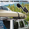 Heavy duty ratchet tie-down straps shown on a vehicle roof rack against a mountainous backdrop.