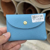 A light blue genuine leather card holder with a gold stud, shown being held by a hand.