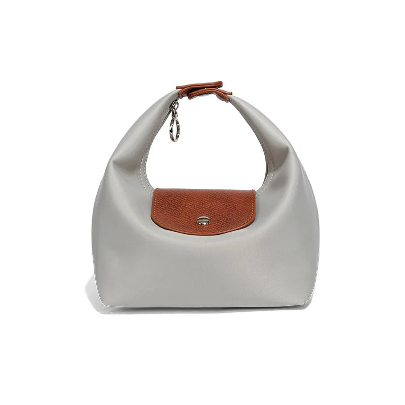 A light gray waterproof nylon crossbody bag with a brown leather strap and flap.