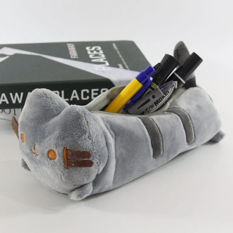 A gray cat-shaped pouch filled with various markers and pens, resting on a black box.