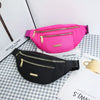A pink multi-layer sports waist bag is displayed next to a black one on a checkered surface.