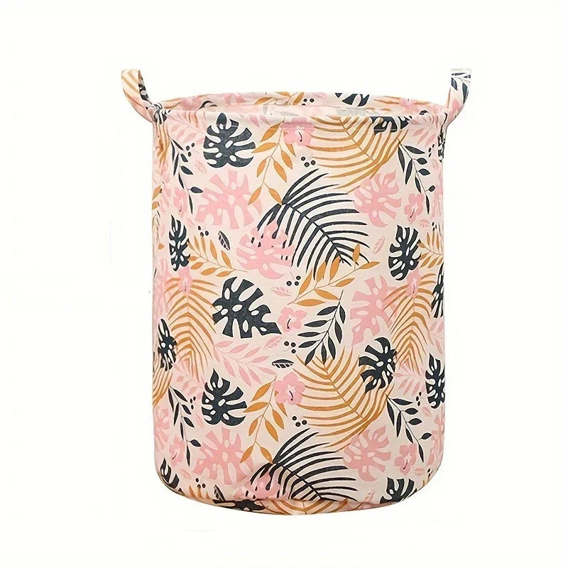 Panier à linge rose en tissu avec motif de feuille tropicale.