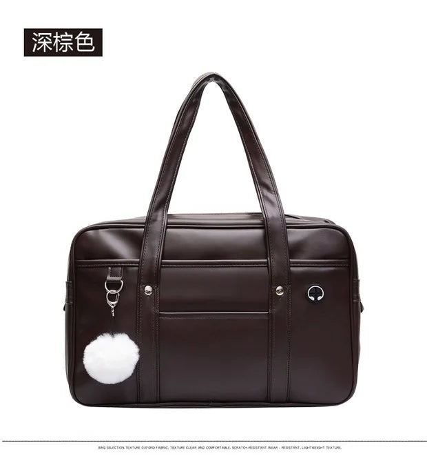 A dark brown leather shoulder bag with a padded design and a white fluffy accent.
