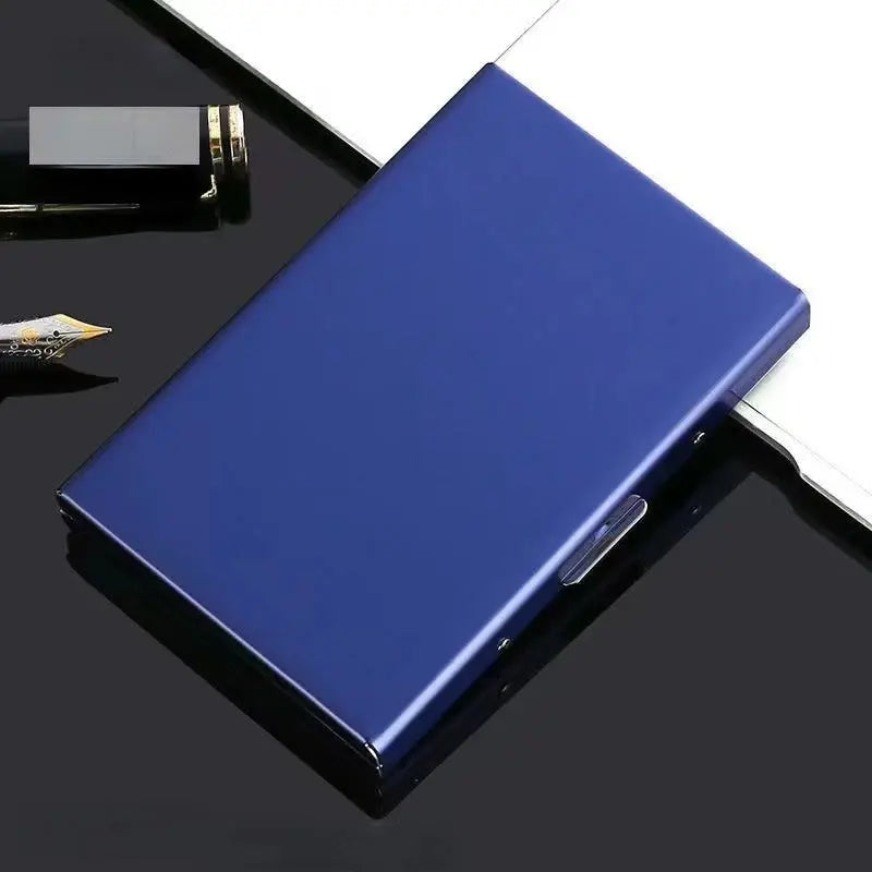 Un porte-cartes métallique bleu foncé fin avec un fermoir argenté sur une surface noire.