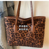 A brown leopard print vintage tote bag with leather handles is shown against a light background.