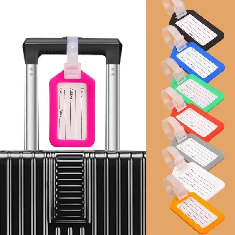 A set of customizable luggage tags in pink, blue, and green are displayed on a black suitcase.