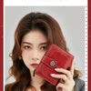 A woman holds a red leather multi-fold RFID protection wallet against her chest.