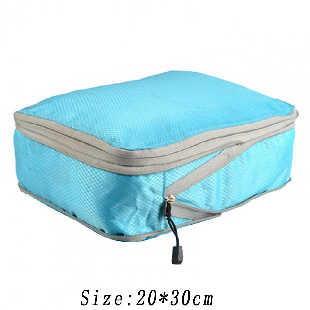Light blue reusable compression packing cube with gray trim and zipper.