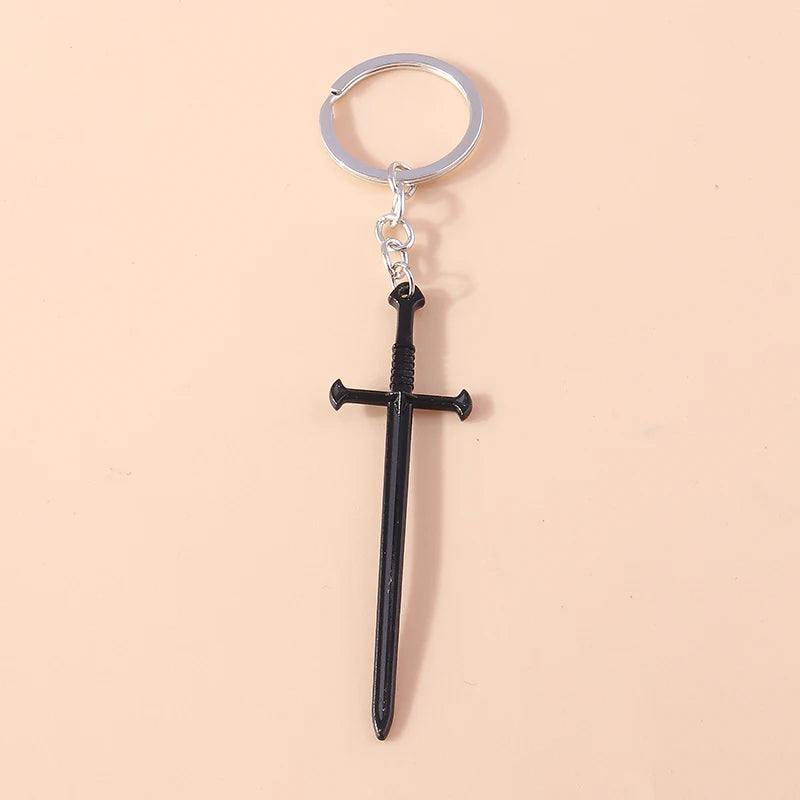 Silver keychain featuring a black sword pendant with a cross and a sun eye design