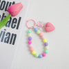 A colorful bead keychain featuring pink and green beads and a heart charm on an O-ring clip.