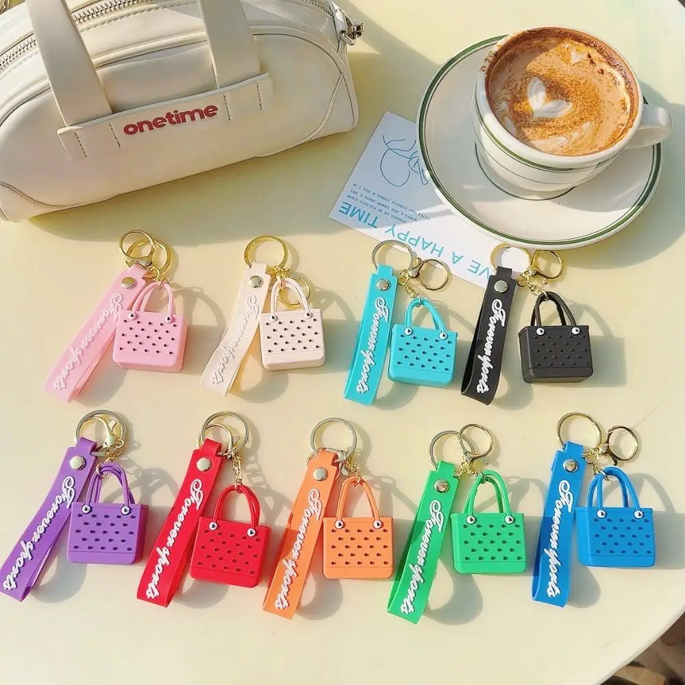 A collection of colorful silicone heart beach bags and keychains displayed on a light surface.