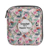 A pink floral patterned storage bag for a crochet hook and sewing accessories.