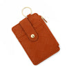 A brown quilted PU leather card holder wallet with a gold ring and tassel attached.