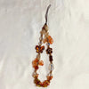 A beaded phone charm strap with an anti-lost lanyard featuring amber and gold colored beads.
