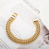 A chunky gold link chain bracelet worn on a wrist, displayed against a white background.