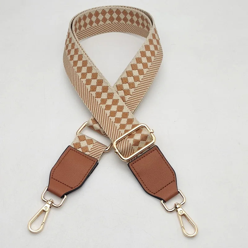 A beige and tan braided nylon strap for a bag, featuring a brown leather adjuster and metal hooks.