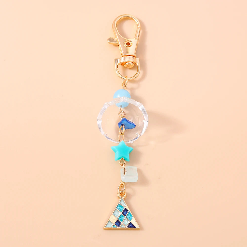 Gold-toned starfish keychain with pearl accents and a triangular charm