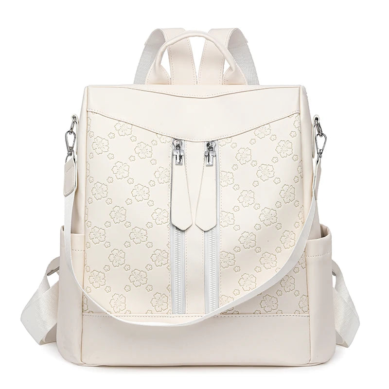 A beige leather anti-theft women's backpack with light stitching and zippered pockets.