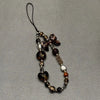 A leopard print bowknot phone lanyard featuring various heart-shaped beads and decorative elements.