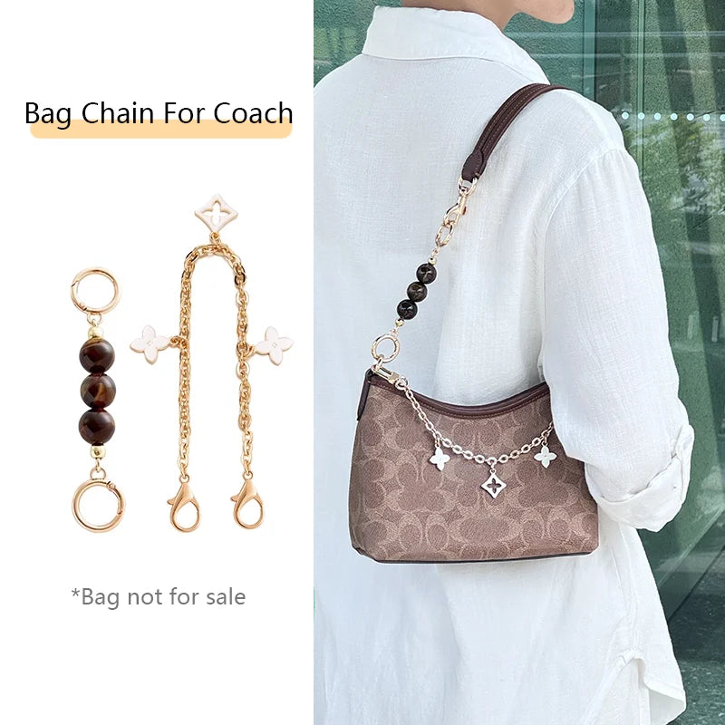 A brown leather bag chain with gold accents is shown attached to a white shirt.