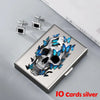 Silver card holder featuring a skull design with blue butterflies, alongside matching silver card clips.