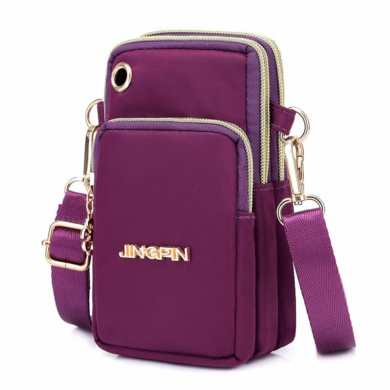 A deep purple waterproof nylon crossbody bag with gold zippers and hardware.