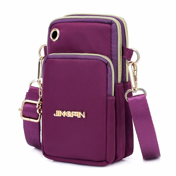 Bolso cruz impermeable de nylon morado intenso con cremalleras y herrajes dorados.
