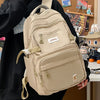 A beige lightweight nylon college backpack with tan straps and zipper details is shown against a blurred background.
