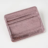 A close-up of a rose gold colored slim leather mini wallet card holder with embossed lines.
