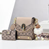 Sac bandoulière en similicuir beige avec détails de chaîne dorée et un charm pompon moelleux.