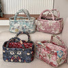 Three quilted fabric storage baskets in various floral patterns and pink tones displayed on a light surface.