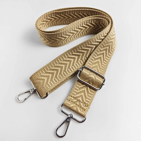 A tan woven leather handbag strap featuring an arrow jacquard pattern with silver hardware.